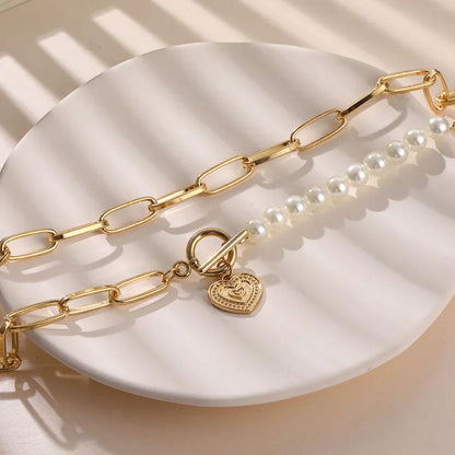 Crossed heart pendant with pearls in gold