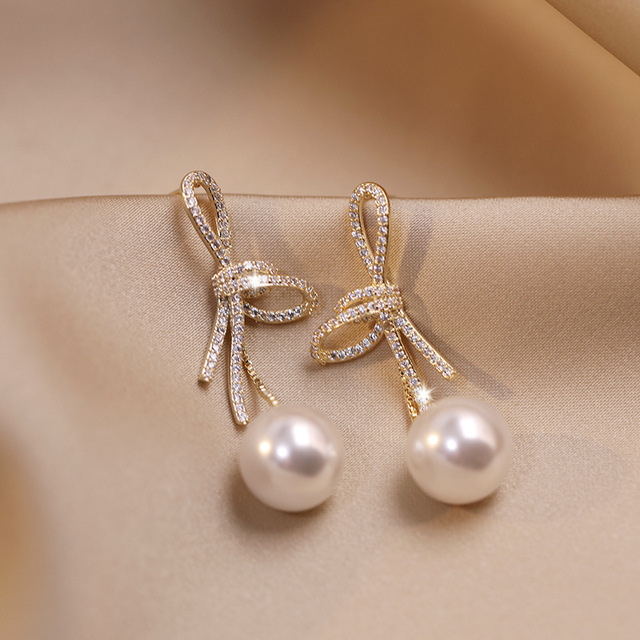 Pearl earrings with shiny gold bow