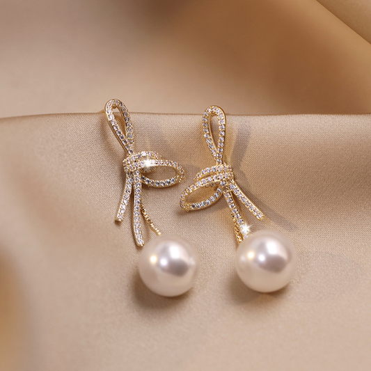 Pearl earrings with shiny gold bow