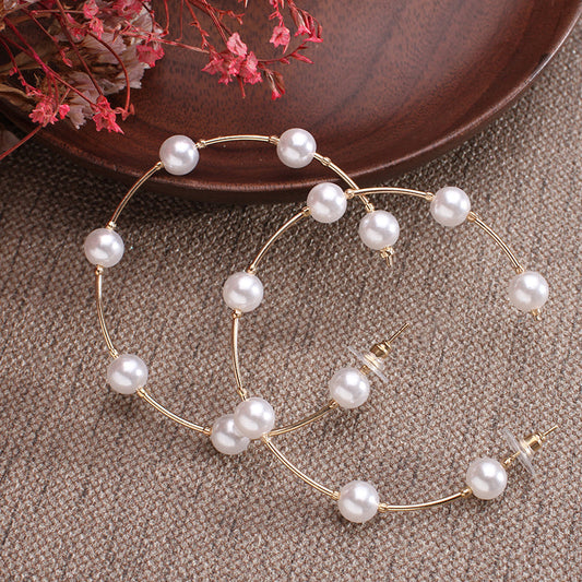 Hoop earrings with a sequence of pink pearls and zirconia